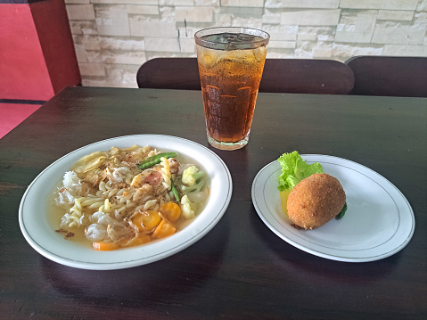 Sop Manten Or Wedding Soup Indonesian. Serving With Snow Peas, Carrots, Fusilli Pasta, Snow Mushrooms, Broccoli, Fried Onion, Potato Chips And Chicken Meat. Potato Croquettes  (Kentang Kroket). Fresh Tea Iced (Es Teh Segar). Food And Drink Menu.