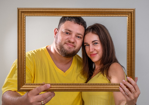 Portrait of a young couple in yellow clothes in a frame