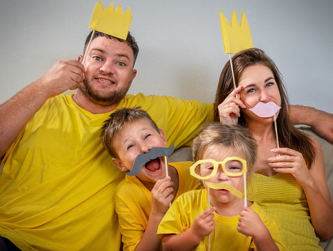Funny family portrait with glasses, mustaches and crowns together