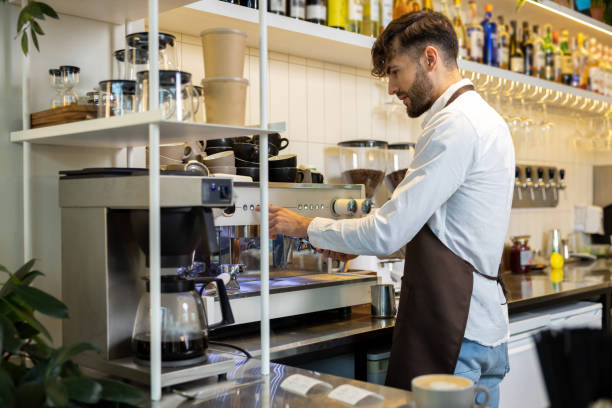 istock Man in apron preparing coffee via professional machine for customer in cafe 2012248149