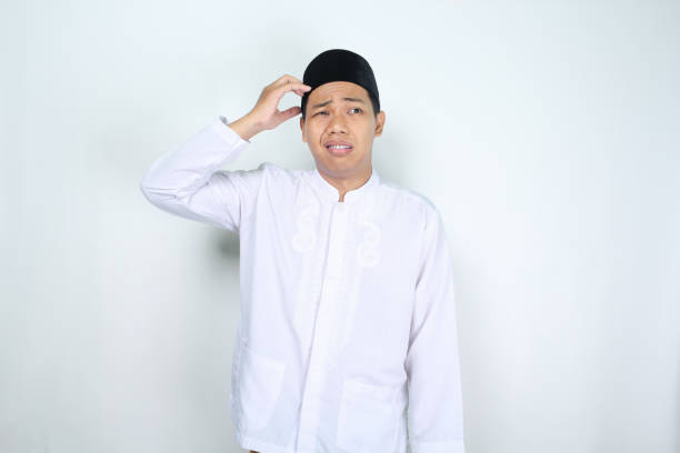istock stressed muslim asian man looking away with holding his head isolated on white background 2012254576