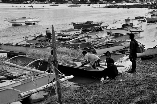 Cebu, Philippines - February 24, 2023: Fishing in Cordova Bay, province of Cebu, has been a key source of livelihood to most natives in the island. At sunset one would normally see the fishermen prepping their gears of various types for night fishing.