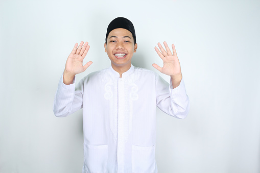 happy muslim man asian waving two hands to give greeting isolated on white background