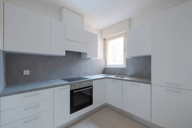 istock Newly renovated kitchen with white doors and gray top. There is a very bright window. 2012296872