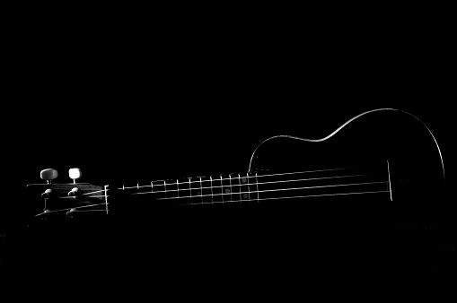 Part of body electric guitar on a black background, copy space. Black and white guitar close up. Creative photography, cropping. Concept music web blog, banner, poster, cover