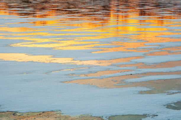istock The lake is covered with winter ice, which reflects the sunset sky in warm colors 2012306579