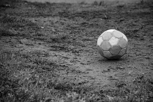 A solitary black and white soccer ball resting on an empty field