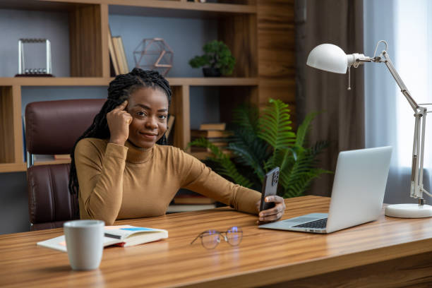 istock Smiling woman sitting at workplace with laptop doing her remote work 2012327561