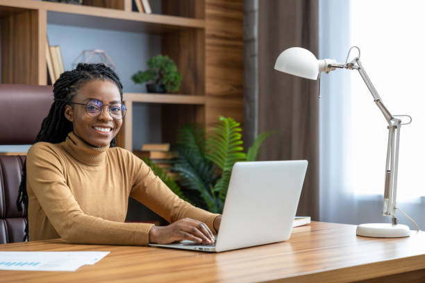 istock Professional woman in glasses with dreadlocks freelances from home 2012328104