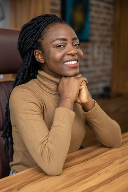 istock Smiling satisfied multicultural woman sitting at table in home office 2012328665