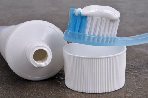 Toothbrush with toothpaste with an open tube of toothpaste close-up