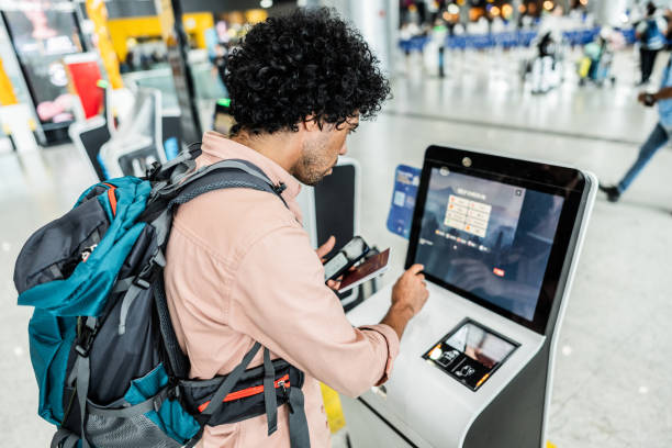 istock Mid adult man using self service check-in machine at airport 2012354524