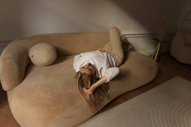 istock A beautiful blonde is posing on a beige sofa in sunlight 2012362361