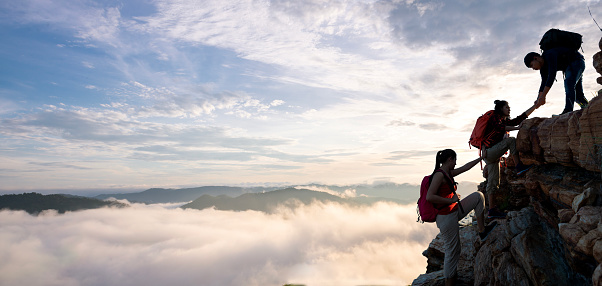 Asian hiking help each other on mountains view . teamwork concept