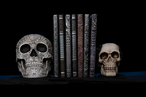 Antique embossed books with sculptured skull book ends with Smokey and spooky background Handmade with silicon resins and sand moulds homemade by photographer