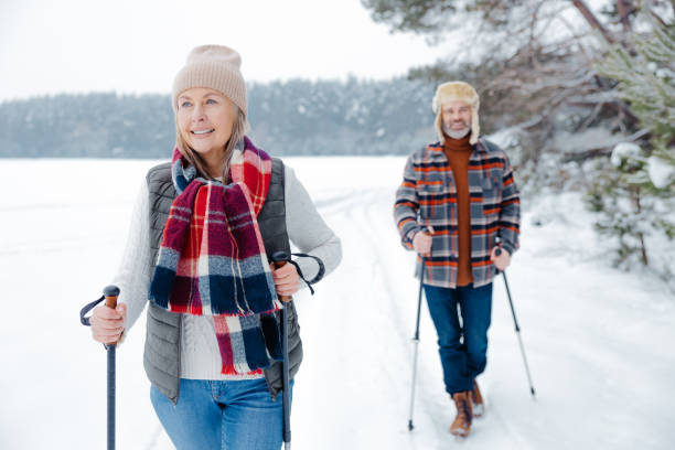 istock Man and woman looking enjoyed and contented while walking with sticks 2012386476