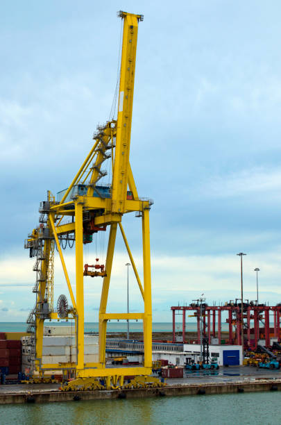 istock Detailed view of crane bridge for unloading or loading containers to the cargo freight ship from port area. Import, export and business logistic. International water transport 2012386496