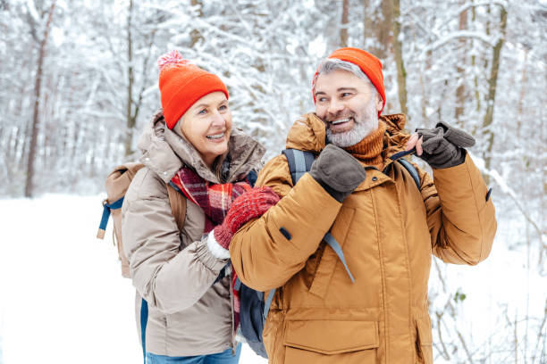 istock Mature couple in a winter forest feeling happy 2012386549
