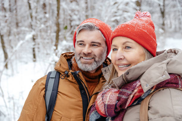 istock Mature couple in a winter forest feeling happy 2012386552