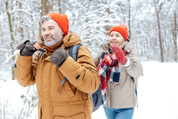 istock Mature couple in a winter forest feeling happy 2012386553