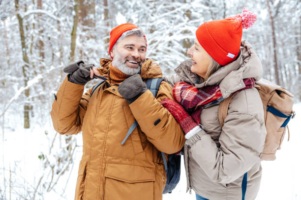 istock Mature couple in a winter forest feeling happy 2012386558