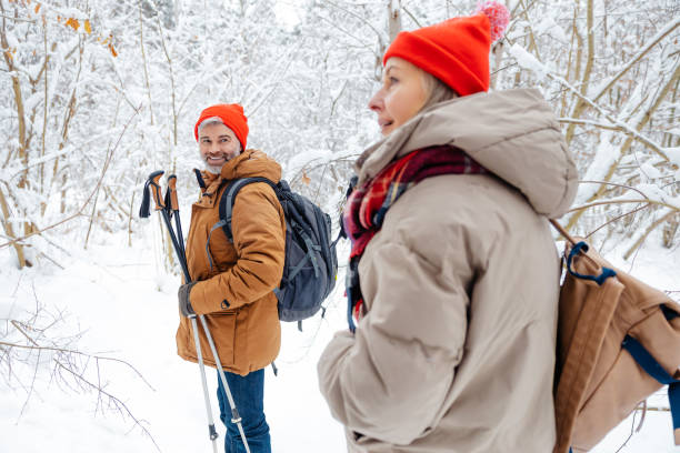 Winter park. Mature couple feeling enjoyed while having a walk in a winter park