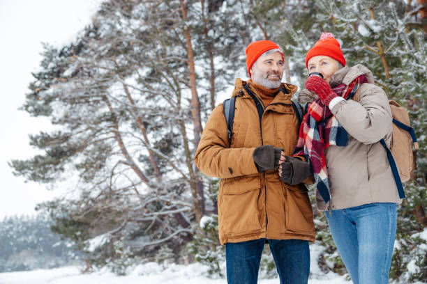 istock Two people standing on a big tree background in a winter forest 2012386633