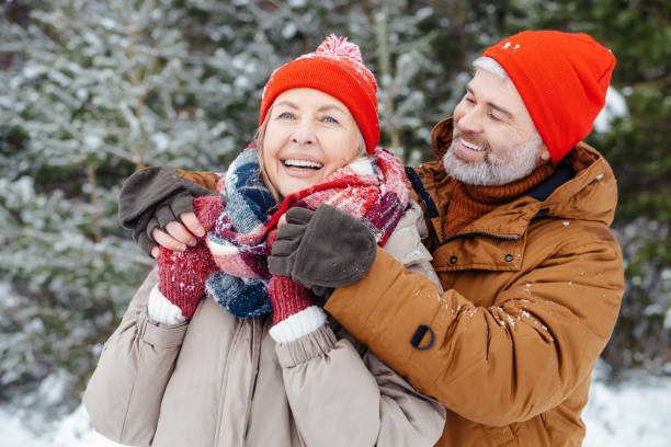 istock Mature couple playing snowballs and looking enjoyed 2012386670