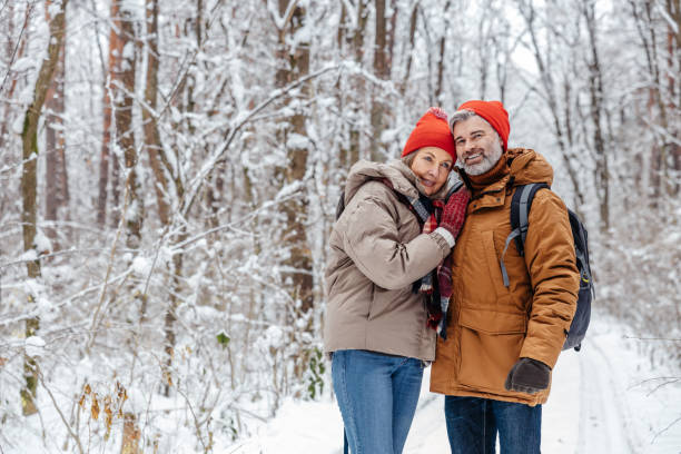 istock Happy mature couple in a snowy forest 2012386700