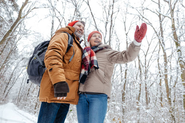 istock Mature couple in a snowy forest feeling excited 2012386704