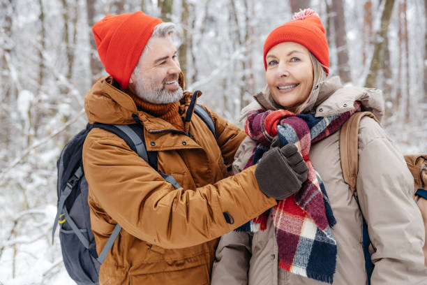 istock Mature couple in a winter forest feeling happy and peaceful 2012386710