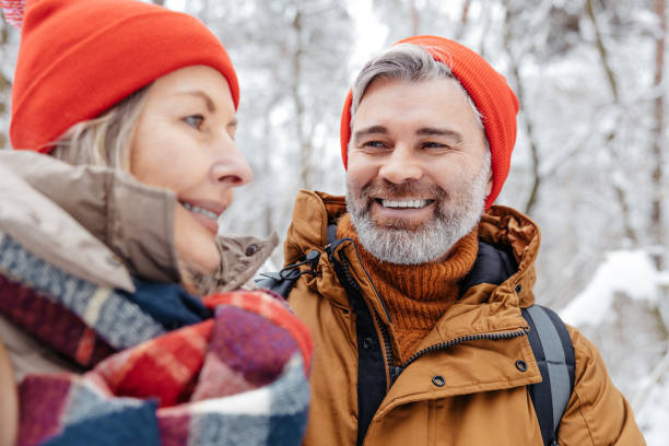 istock Mature couple in a winter forest feeling happy and peaceful 2012386718
