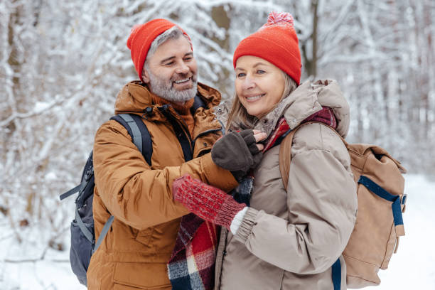 istock Happy mature couple spending time in a snowy forest 2012386719
