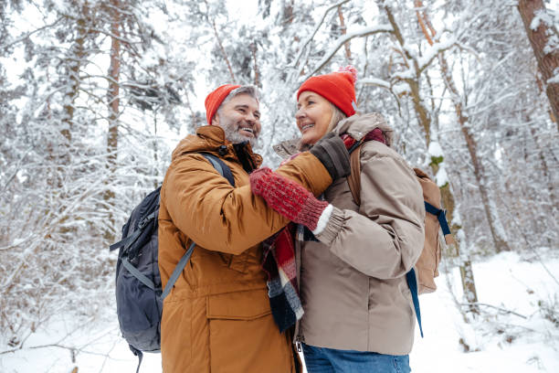 istock Happy mature couple spending time in a snowy forest 2012386724