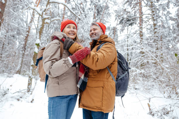 istock Happy mature couple spending time in a snowy forest 2012386726