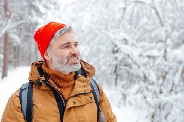 istock Mature caucasian man in red hat on a snowy background looking contented 2012386792
