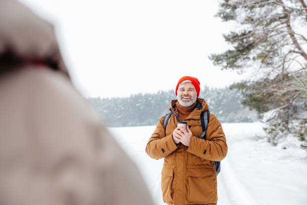 istock Smiling man with thermos in hands looking contented 2012386806