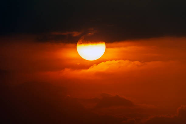 istock sunset with a dark appearance, round red sun 2012404650