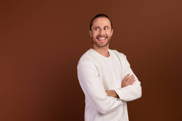 istock Photo of good mood dreamy guy dressed white pullover arms folded looking back empty space isolated brown color background 2012440931