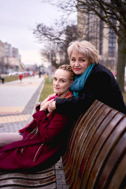 istock an old mother hugs her daughter on a spring street 2012445937
