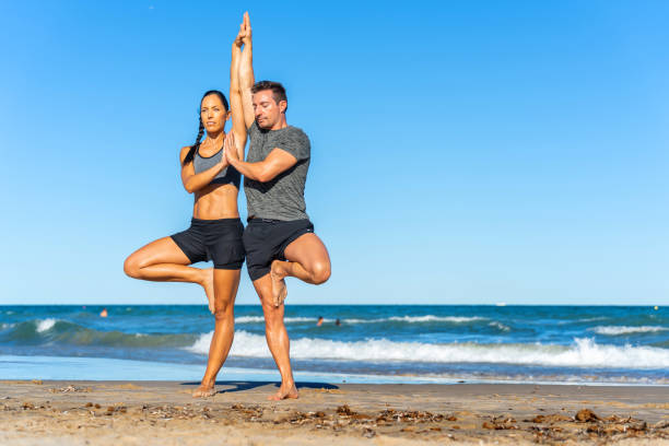 istock Middle aged couple exercising together on the beach this summer 2012454401