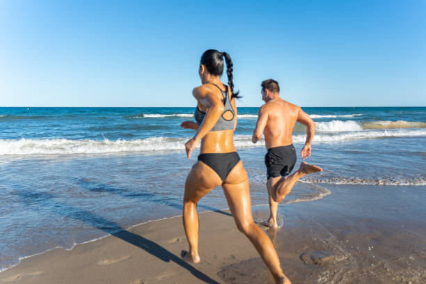 istock Middle aged couple exercising together on the beach this summer 2012454952