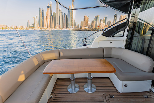 Luxurious motor yacht in deep blue sea of middle east showing skyline and sky scrappers