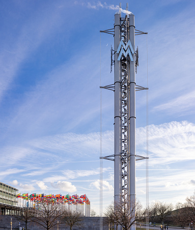 On February 13th 2024, the Commercial Sign on a Tall Totem of the International Fair Building and Congress Complex in Leipzig, Germany, decorated with flags of many countries around  the world
