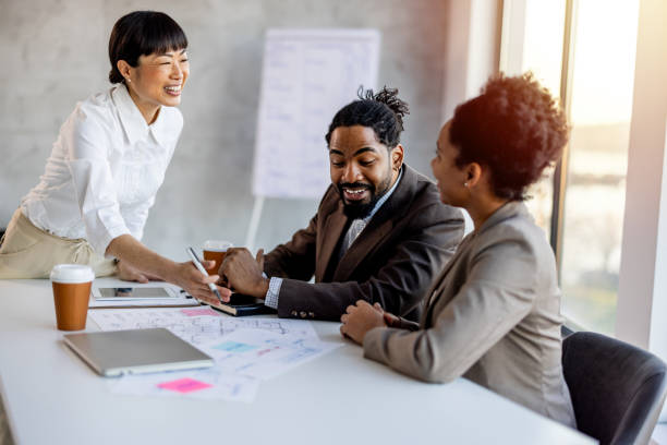 istock Multi racial diverse group of people working with Paperwork on a board room table at a business presentation or seminar. 2012458075