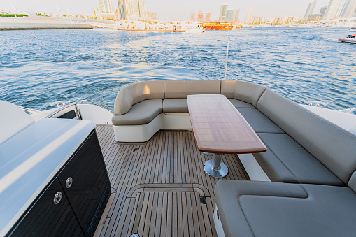 Luxurious motor yacht in deep blue sea of middle east showing skyline and sky scrappers