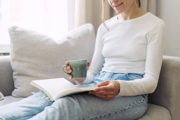 istock Close up view of female hand holding ceramic cup with coffee and notebook 2012461840