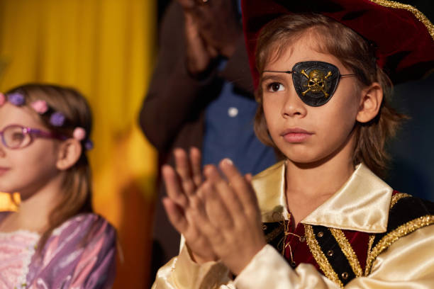 istock Boy Wearing Pirate Costume Standing on Stage Applauding 2012470302
