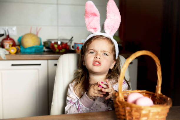 istock Little beautiful girl with easter bunny ears on with her basket of easter eggs Happy Easter holiday. 2012504053