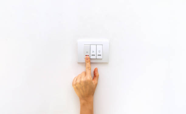 istock Controlled home energy consumption. Female finger on light switch close-up. 2012504078
